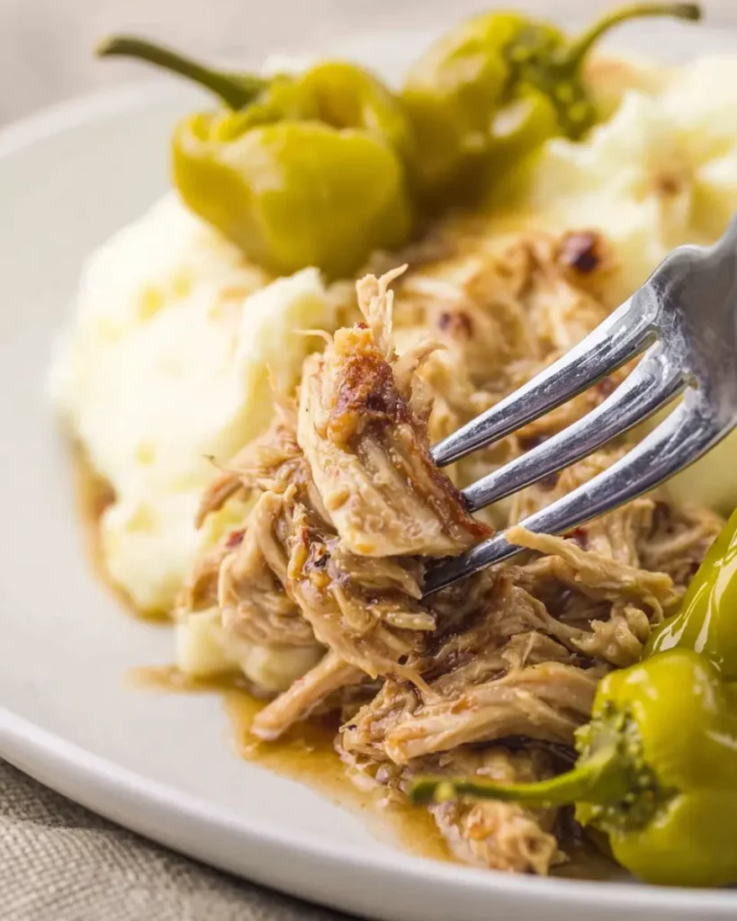Mississippi Chicken (Crockpot Style) – Savory, Easy Comfort Food 7 Close-up of shredded Mississippi chicken with pepperoncini over mashed potatoes