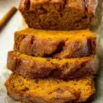 Perfect Pumpkin Bread That's Moist with a Crunchy Sugar Crust 9 Sliced pumpkin bread loaf with sugar crust on parchment paper