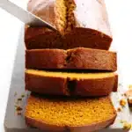 Pumpkin Muffins – Soft, Spiced, and Perfect Every Time 12 Freshly sliced pumpkin bread with golden crust and moist spiced interior on a cutting board