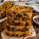 Stacked slices of pumpkin chocolate chip bread with melted chocolate chips on parchment