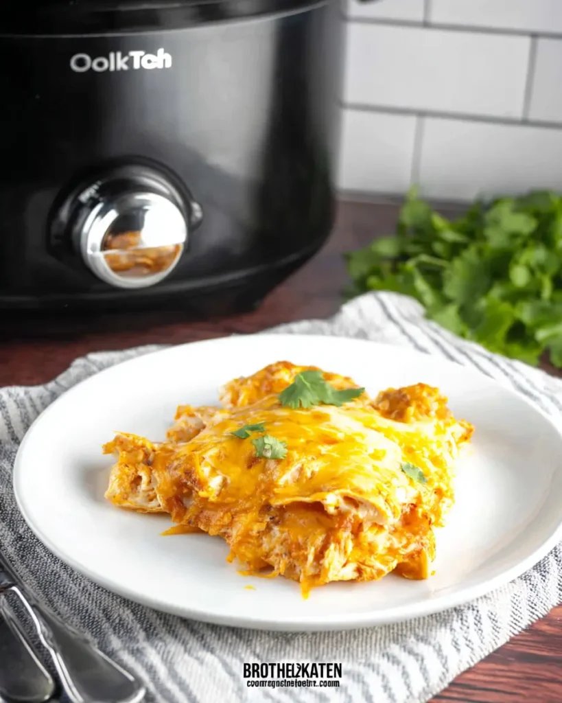 Cheesy chicken enchilada casserole served on a white plate with cilantro garnish
