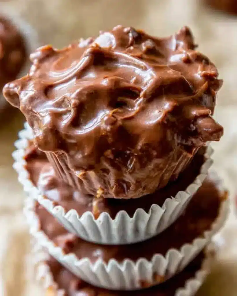 20+ Easy Crockpot Meals for Summer That Won’t Heat Up Your Kitchen 10 Stacked slow-cooked chocolate clusters in white paper liners with glossy swirls