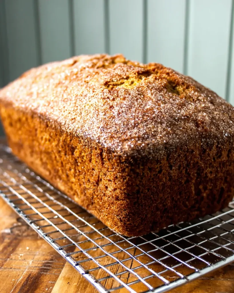 Perfect Pumpkin Bread That's Moist with a Crunchy Sugar Crust 8 Whole pumpkin bread loaf with sugar crust cooling on a wire rack