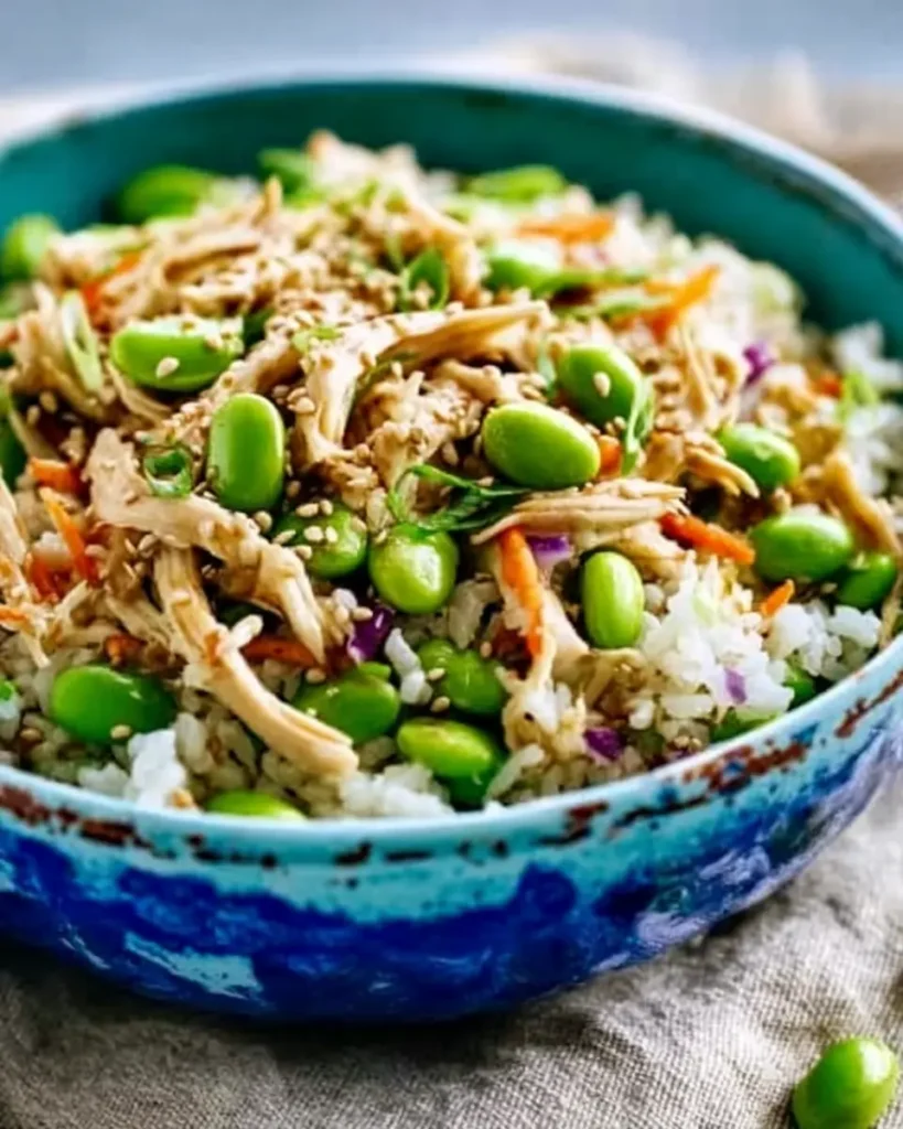 70+ Easy Rotisserie Chicken Recipes for Fast, Flavorful Weeknight Meals 7 Asian-inspired rotisserie chicken rice bowl with edamame, sesame seeds, and colorful vegetables