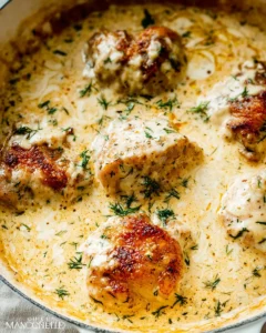 Golden seared chicken thighs baked in creamy garlic Parmesan sauce with fresh dill, served in a stainless steel skillet