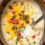 Creamy Potato Soup Recipe – Quick, Easy, and Comforting 14 Creamy potato soup in a pot with cheddar cheese, crispy bacon, green onions, and sour cream topping.