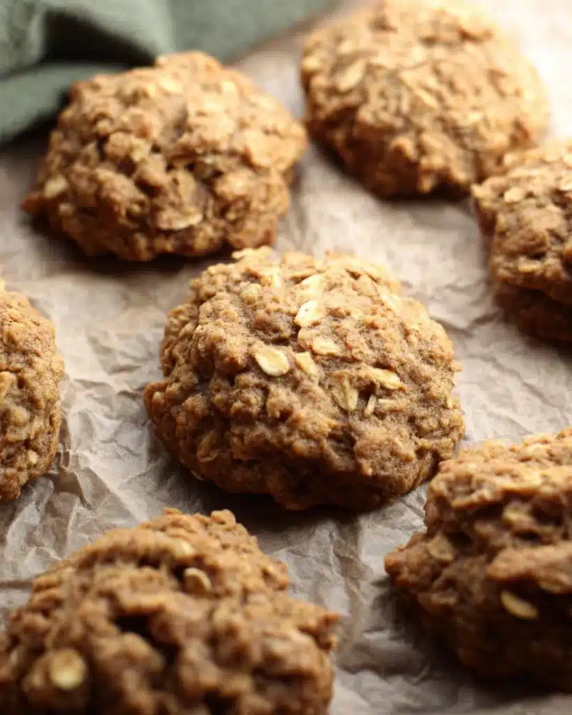 Soft Pumpkin Oatmeal Cookies – The Perfect Fall Treat 10 Freshly baked soft pumpkin oatmeal cookies on parchment paper with golden-brown texture