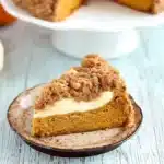 Pumpkin Cream Cheese Crumb Cake for Cozy Fall Baking 11 Slice of pumpkin cream cheese crumb cake with streusel topping on a white plate