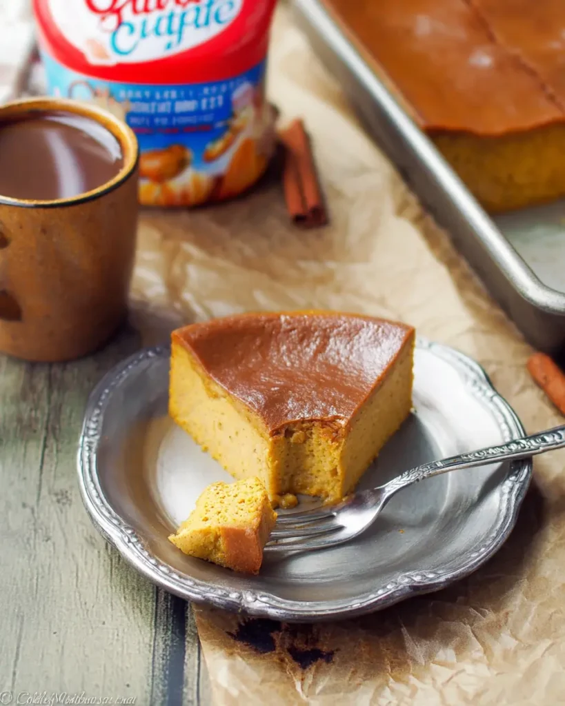 Pumpkin Magic Custard Cake – A Cozy Fall Dessert with Layers of Wonder 9 Slice of pumpkin magic custard cake on a rustic metal plate with fork, showing creamy texture