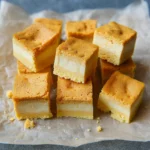 Pumpkin Magic Custard Cake – A Cozy Fall Dessert with Layers of Wonder 12 Close-up of sliced pumpkin magic custard cake with visible three-layer texture on a rustic background