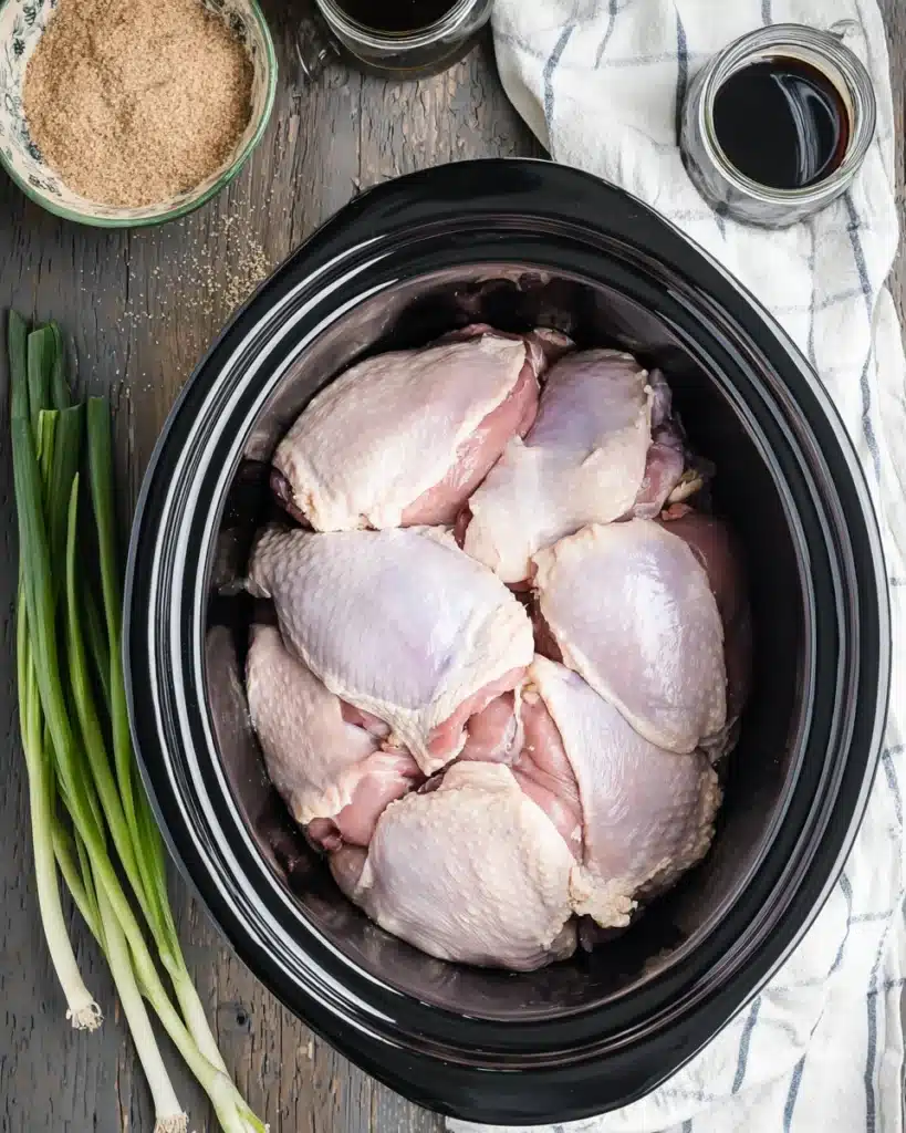 Raw chicken thighs in crock pot for bourbon chicken recipe prep