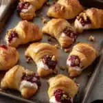 Cranberry Cream Cheese Crescent Bites – Festive and Easy Recipe 14 Golden cranberry cream cheese crescent bites with pecans on a rustic baking tray
