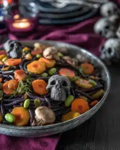 Halloween pasta salad with mushroom skulls, carrots, and black pasta in a spooky setting