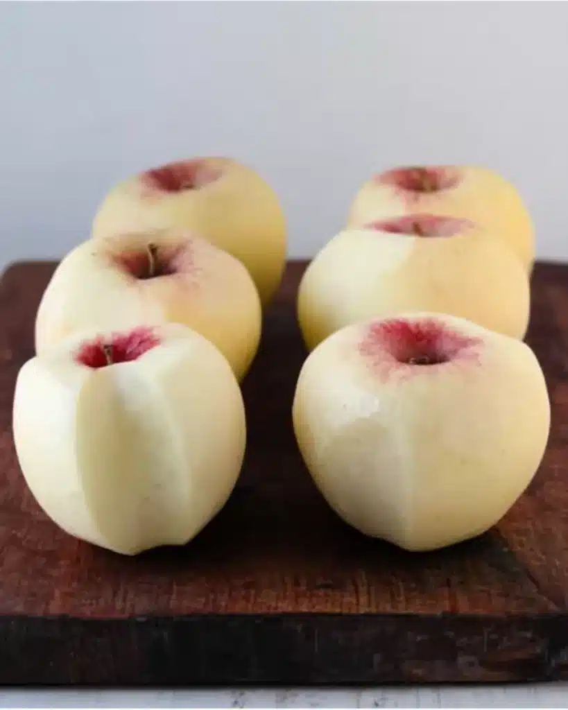 Homemade Apple Juice Recipe : Easy Canning Instructions 12 Peeled apples on a wooden board ready for homemade apple juice