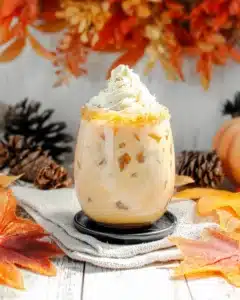 Pumpkin Spice White Russian with whipped cream and golden sugar rim