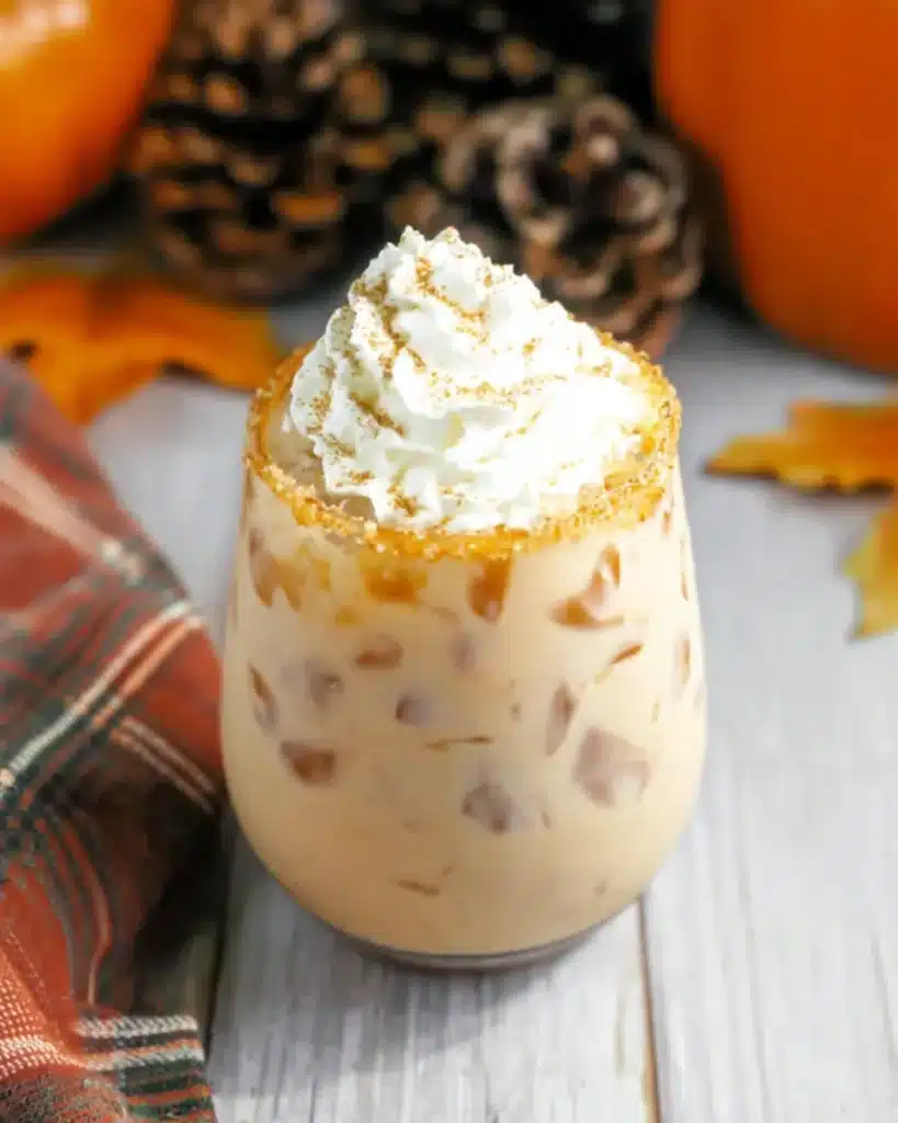 Pumpkin Spice White Russian Recipe | A Festive Fall Cocktail 10 Pumpkin Spice White Russian with whipped cream and sugar rim on rustic table