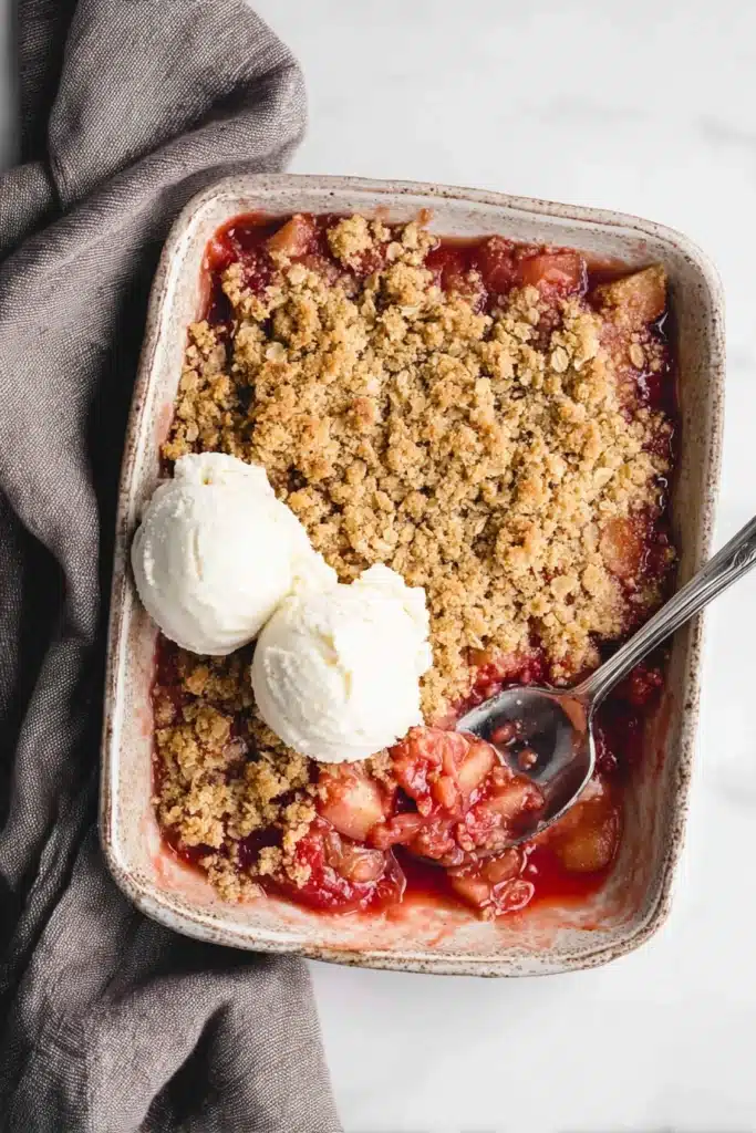 Easy Rhubarb Crisp Recipe That’s Sweet, Tangy, and Comforting 2 Easy Rhubarb Crisp baked in dish with crumble topping and ice cream
