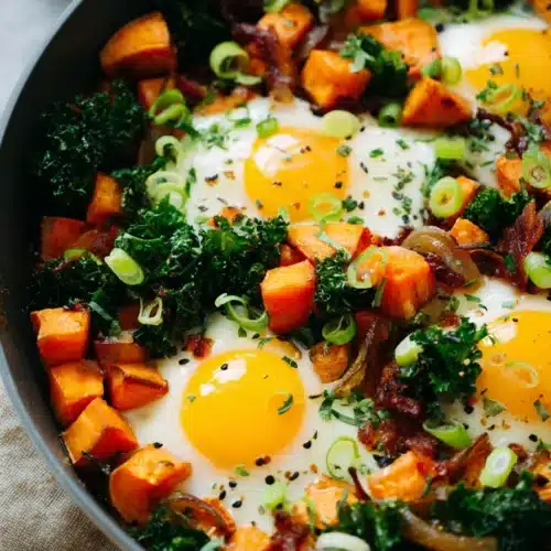Sweet Potato Breakfast Hash Recipe You’ll Love Every Morning 4 Sweet potato breakfast hash with eggs, kale, and crispy bacon in skillet
