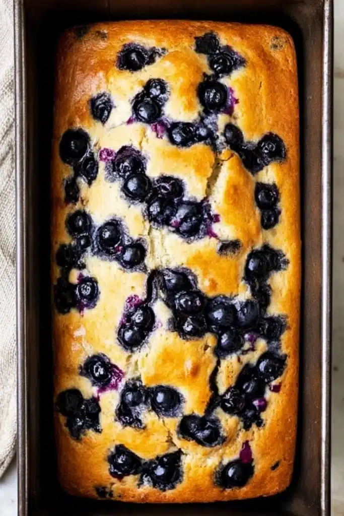 Lemon Blueberry Bread 2 Lemon blueberry bread baked in loaf pan with golden crust and blueberries