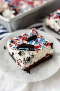 No bake Oreo cheesecake bars with sprinkles on white plate