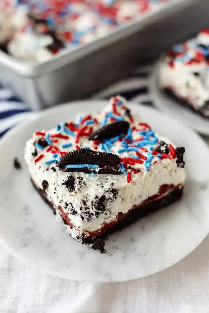 No bake Oreo cheesecake bars with sprinkles on white plate
