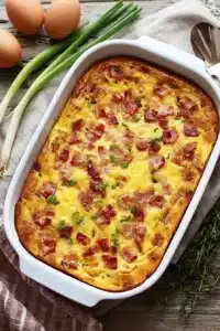 cheesy breakfast casserole with crispy bacon in baking dish