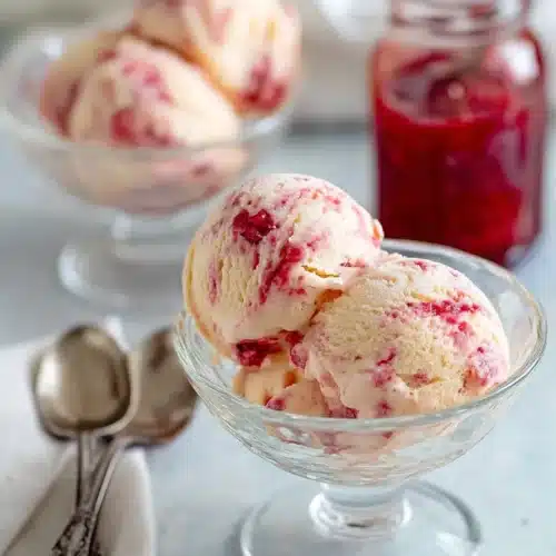 Rhubarb ice cream scoops with red fruit swirl in bowls
