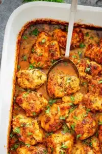 Oven baked chicken bites in buttery sauce with crispy edges and parsley