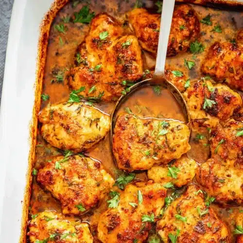 Oven baked chicken bites in buttery sauce with crispy edges and parsley
