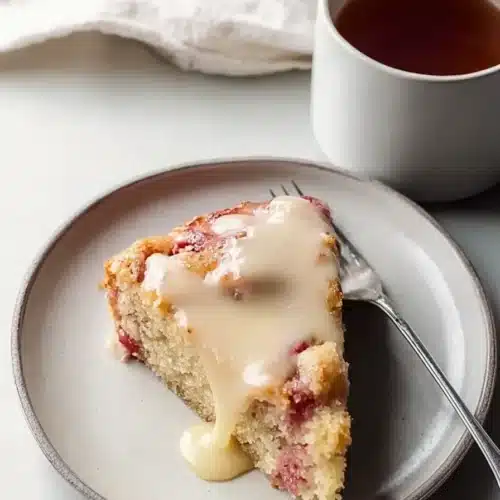 Warm Rhubarb Cake with creamy butter sauce on plate