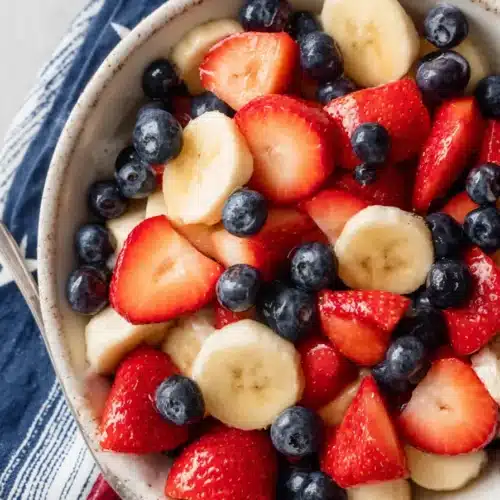 4th of July fruit salad with strawberries blueberries and bananas in a white serving bowl