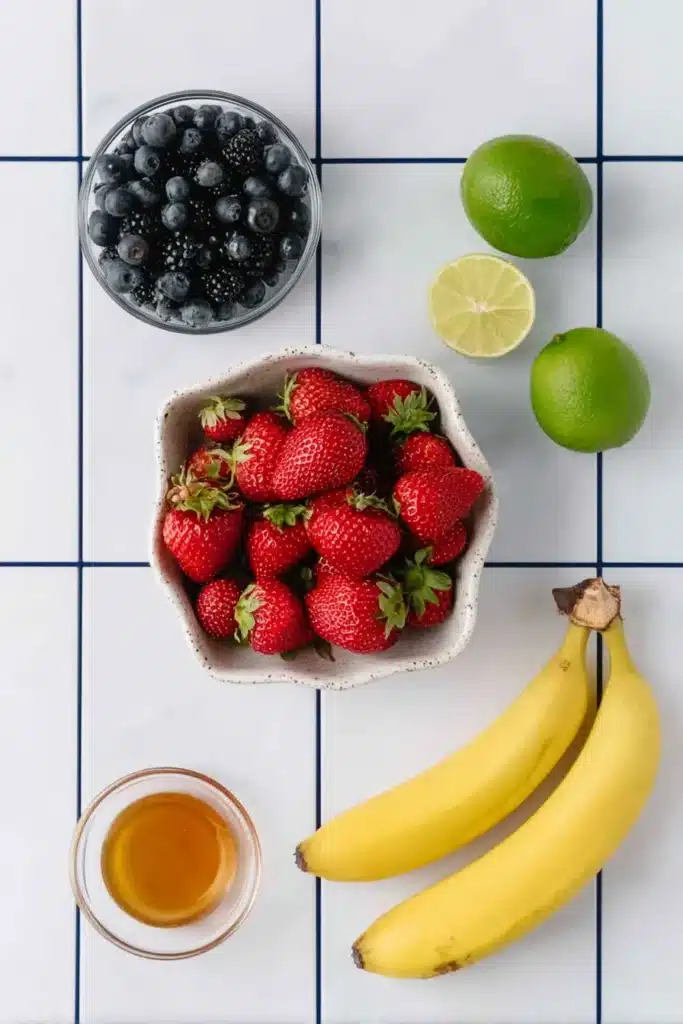 Ingredients for 4th of July Fruit Salad with strawberries blueberries bananas and honey