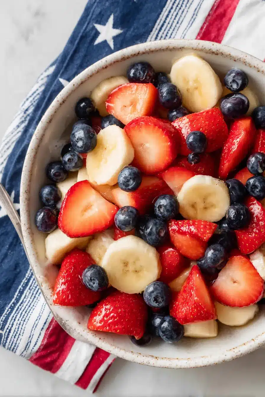 4th of July fruit salad with strawberries blueberries and bananas in a white serving bowl