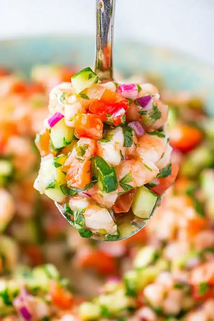 Close up spoonful of fresh Shrimp Ceviche with cucumber and tomatoes