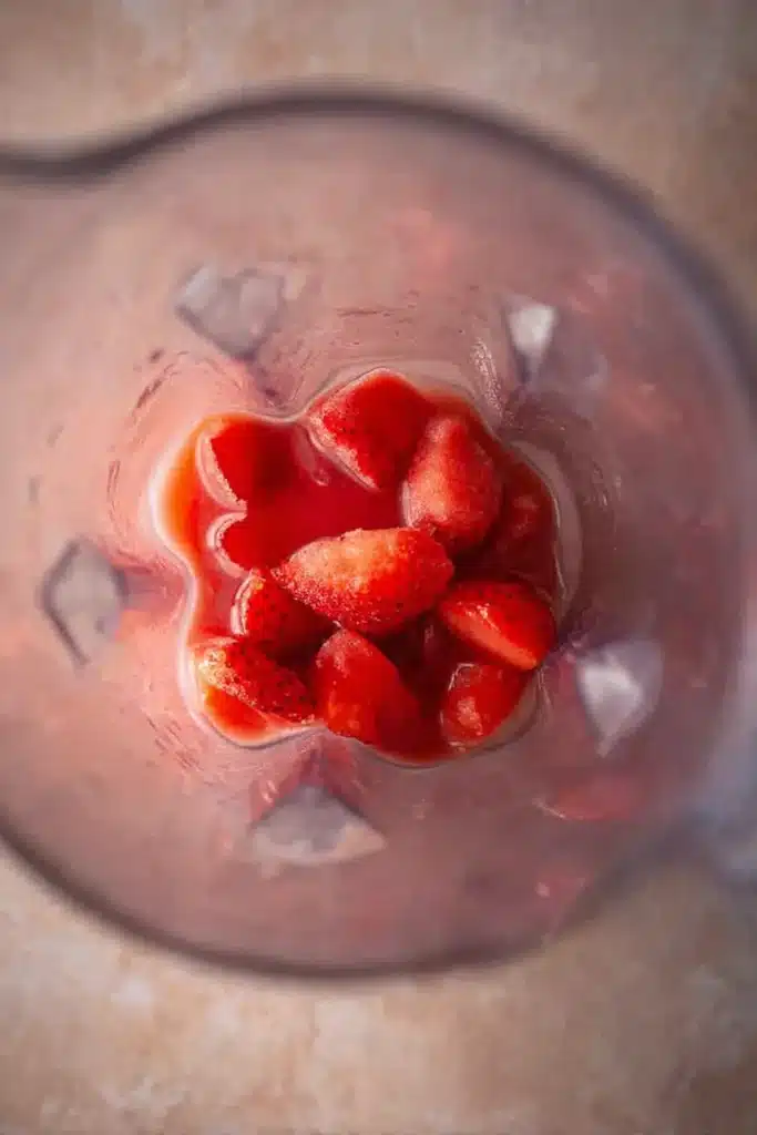 Frozen Strawberry Lemonade ingredients with strawberries, lemonade, and ice