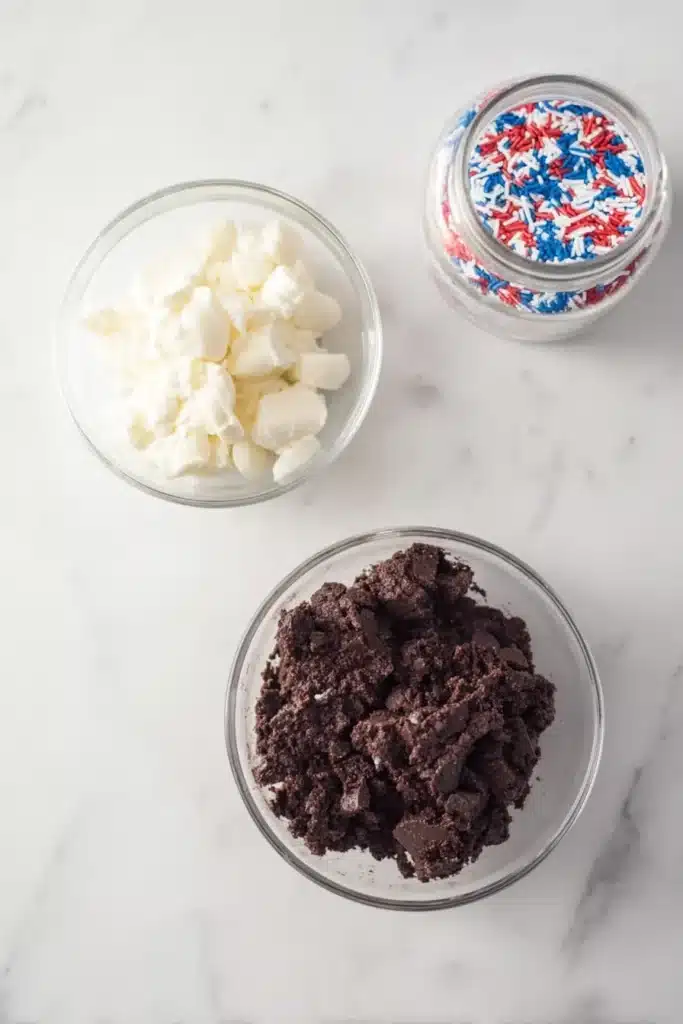 Patriotic Oreo Balls ingredients with Oreo mixture, white chocolate, and patriotic sprinkles