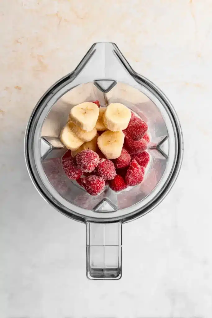 Strawberry Banana Smoothie Bowl 2 Strawberry Banana Smoothie Bowl ingredients in a blender before mixing