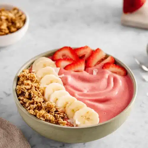 Strawberry Banana Smoothie Bowl 4 Strawberry banana smoothie bowl with fresh fruit and granola toppings