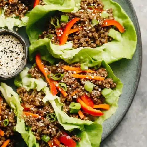 Ground Beef Lettuce Wraps with sesame seeds, peppers, and carrots in crisp butter lettuce