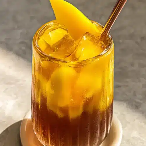 Homemade Mango Iced Tea with fresh mango garnish and ice