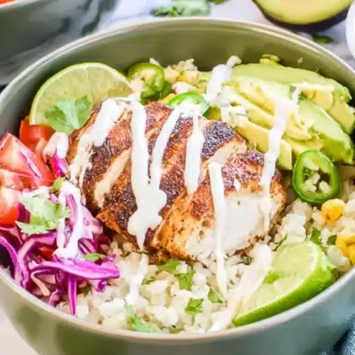 Low Carb Fish Taco Bowls with cod, cauliflower rice, avocado, slaw, and lime crema