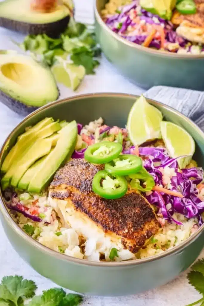 Low Carb Fish Taco Bowls with baked cod, avocado, cauliflower rice, slaw, and lime